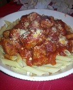 A plate of pasta with meatballs and sauce.