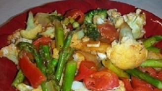 A red plate of food with vegetables on it.