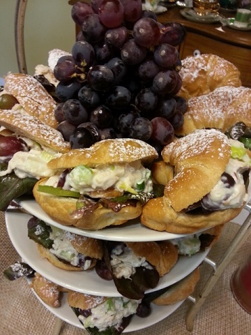 A stack of pastries and grapes on plates.