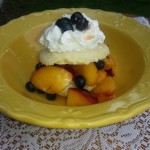 A yellow plate topped with fruit and whipped cream.