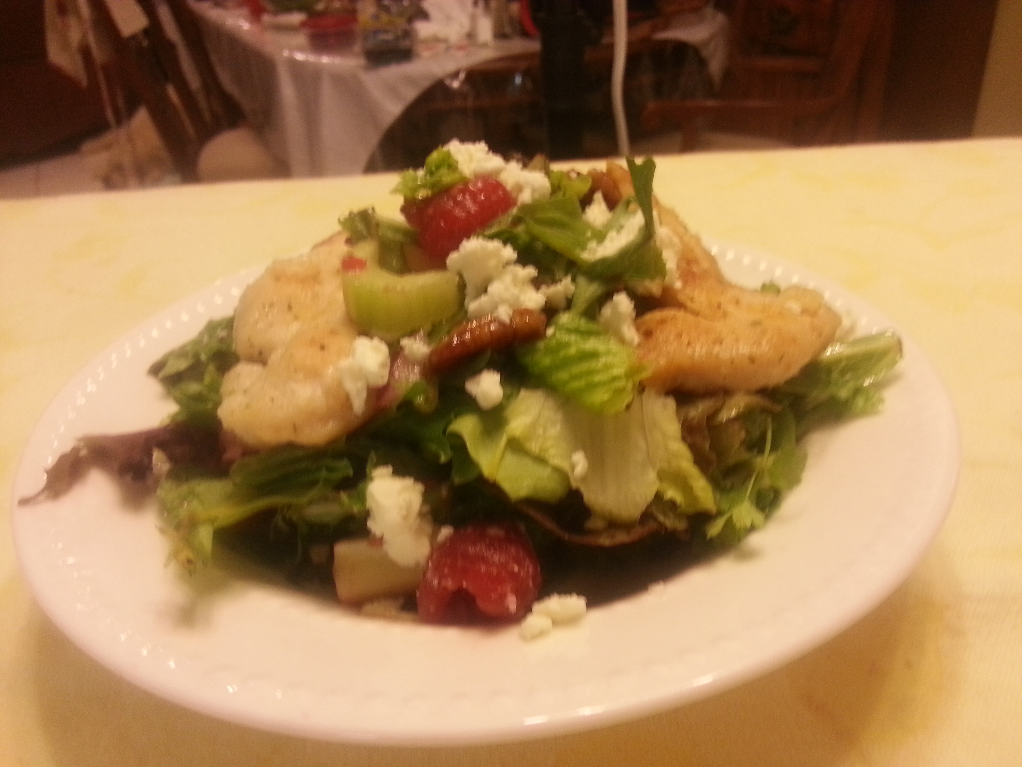 A salad with chicken, strawberries and feta cheese.
