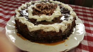 A cake with white frosting and chocolate on top.