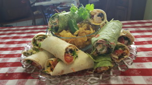 A plate of food with many wraps and salad.