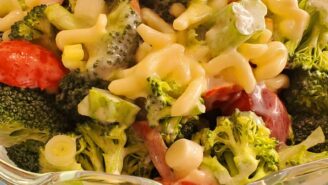A bowl of broccoli, corn and pasta salad.