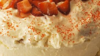 A cake with white frosting and strawberries on top.