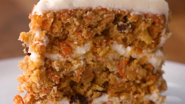 A carrot cake with white frosting on top.