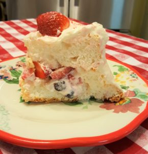 A piece of cake with strawberries on top.