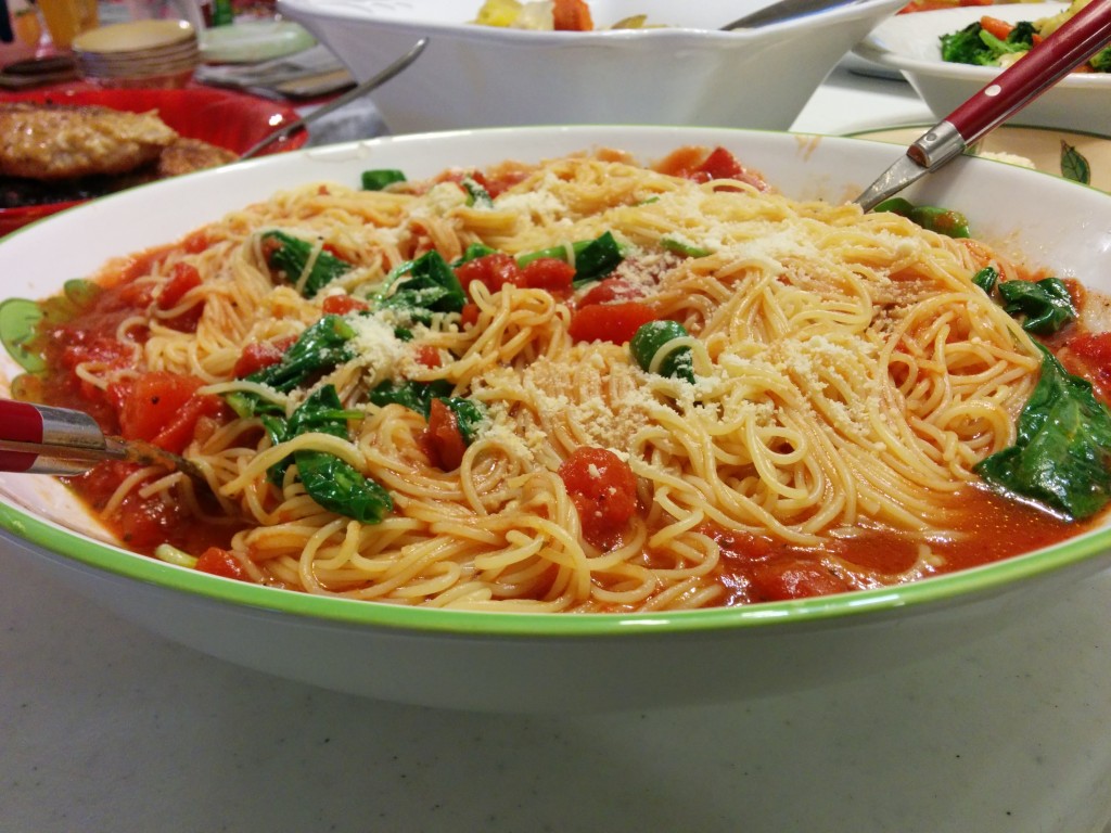 A bowl of pasta with tomato sauce and cheese.