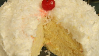 A white cake with coconut on top of it.