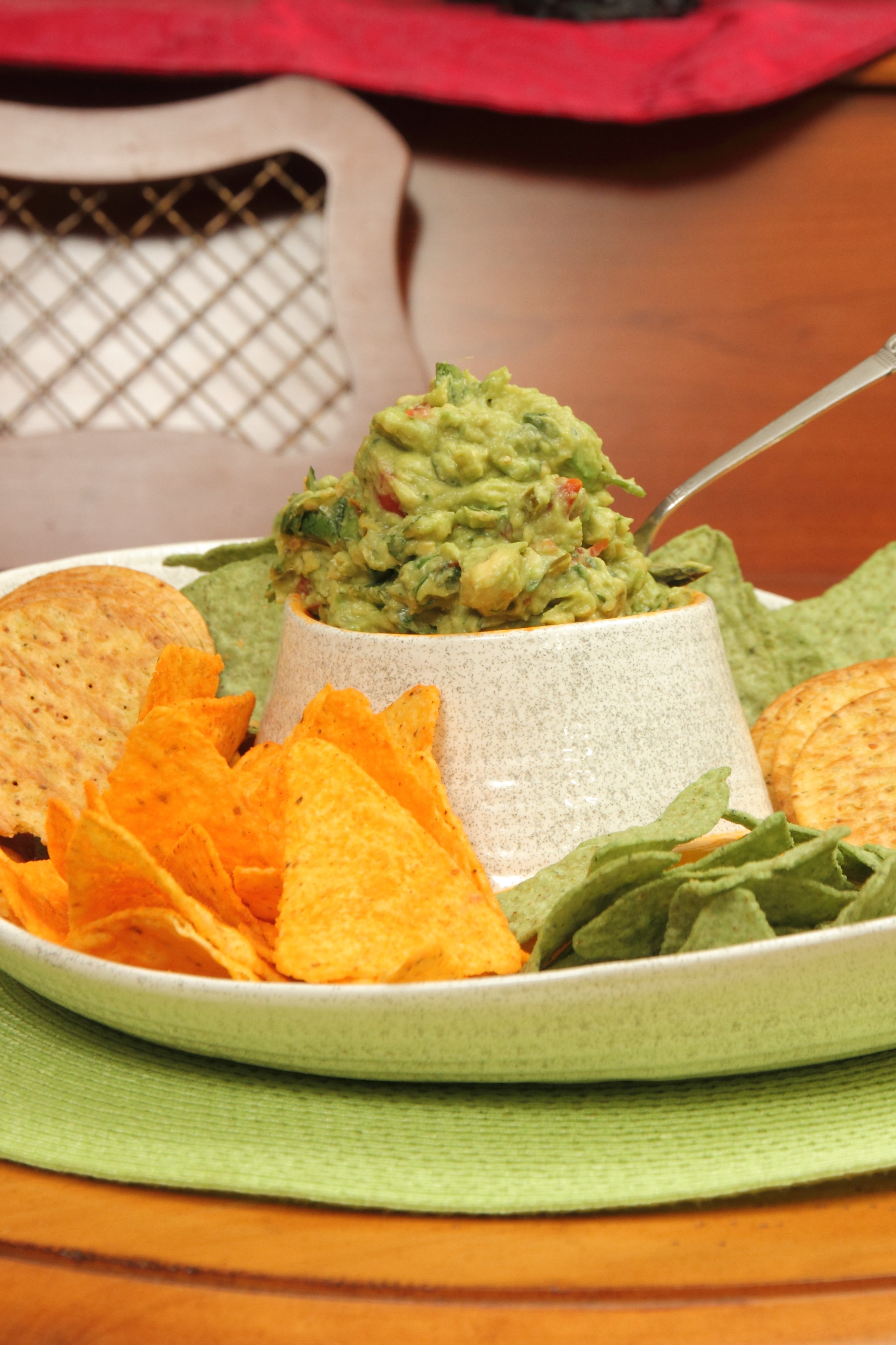 A plate of chips and guacamole on the table.