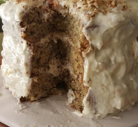 A piece of cake with white frosting on top.