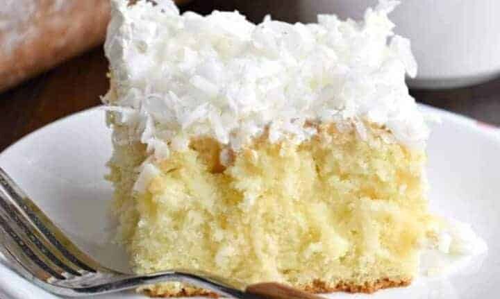 A piece of cake with coconut on top.