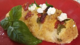 A piece of chicken with feta and basil on top.